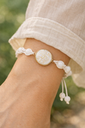 Bracelet délicat de perles fines sur macramé et pièce de porcelaine